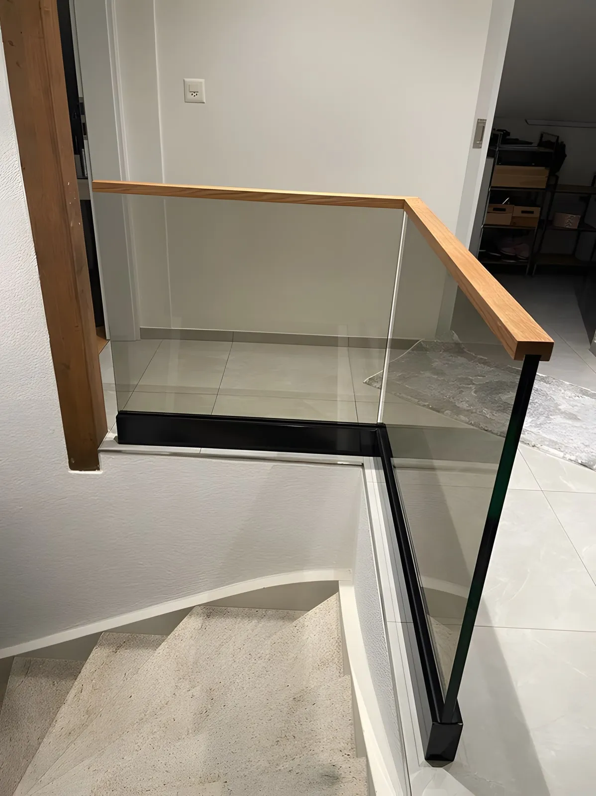 Glasgeländer mit Holzhandlauf an einer Innentreppe