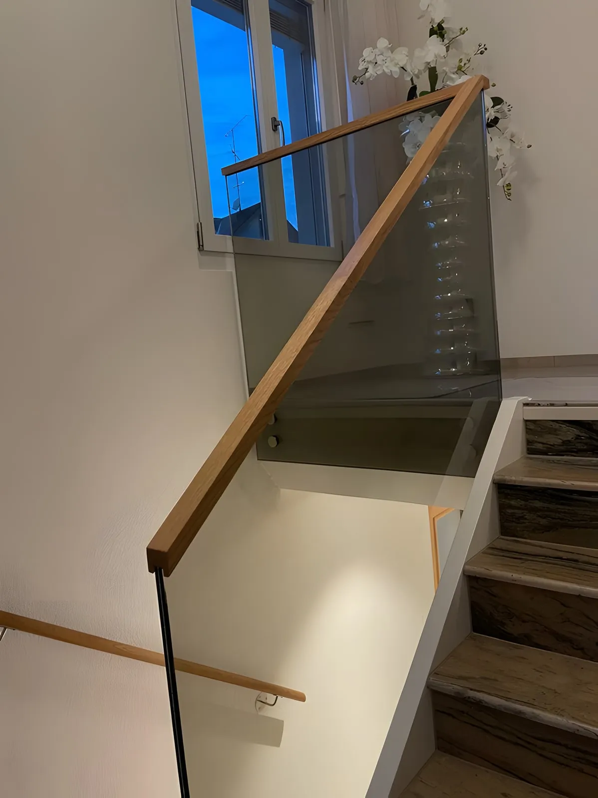 Treppenhaus mit Glasgeländer und Holzhandlauf
