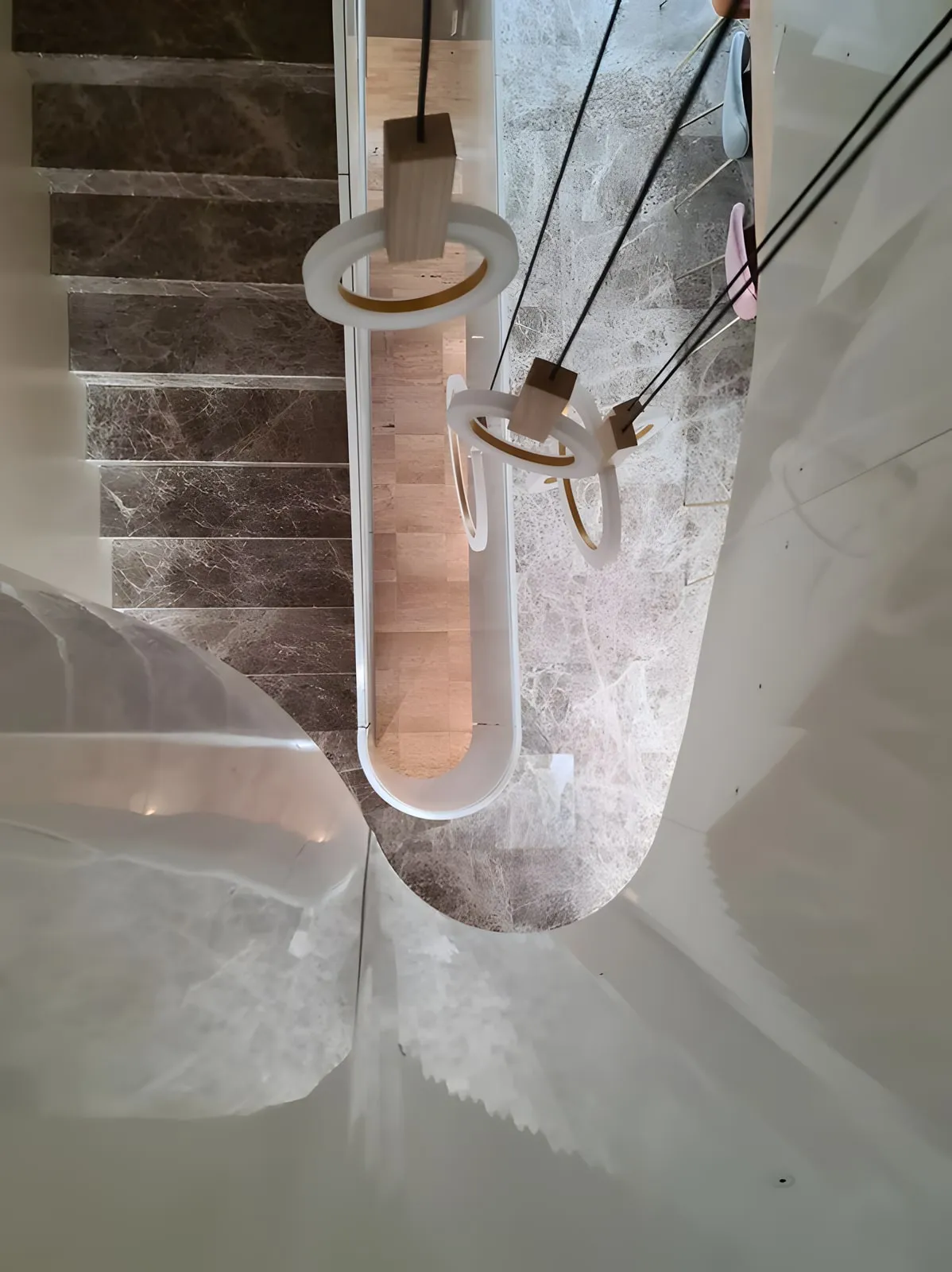 Blick von oben in ein Treppenauge mit geschwungener weisser Brüstung